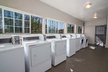a row of white washing machines in a laundromat